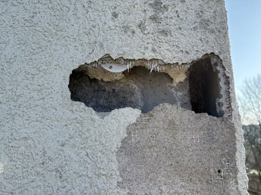 Spechtloch in der Wärmedämmung einer Fassade